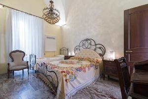 a bedroom with two beds and a chandelier at Palazzo Osanna in Nardò