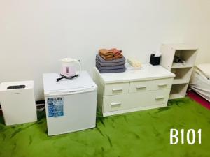 a room with white appliances and green carpet at 冠京ホテル in Tokyo
