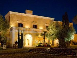 a large white building with lights on it at night at Relais Reggia Domizia in Manduria