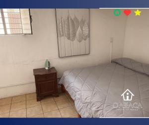 sypialnia z łóżkiem, szafką nocną i zdjęciem w obiekcie Casa Yunissa w mieście Oaxaca