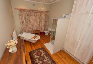 a bathroom with a bath tub and a toilet at Chateau B&B in Piet Retief
