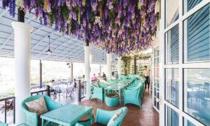 a restaurant with blue tables and purple flowers hanging from the ceiling at The Bluesky Resort @ Khao Kho in Campson