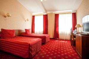 a hotel room with two beds and a television at Asteria Hotel in Saint Petersburg