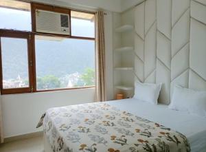 a bedroom with a bed and a large window at Tapovan home by Jabula Getaways in Rishīkesh