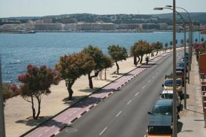 a road with cars parked on it next to the water at Rallye Hotel in L'Escala