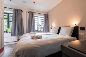 a bedroom with a large bed with towels on it at Central Tilburg Apartments in Tilburg