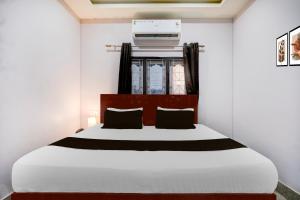 a bedroom with a large white bed and a window at Super Collection O Guwahati Airport Formerly Hotel Aniruddha Grand in Kāhārpāra +21 photos