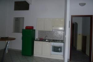 a kitchen with white cabinets and a green refrigerator at Mazzarò Isola Bella in Taormina