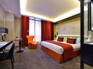 a hotel room with a large bed and a desk at Grand Hôtel La Cloche Dijon - MGallery Collection in Dijon