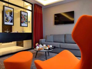 a living room with a couch and a table at Grand Hôtel La Cloche Dijon - MGallery Collection in Dijon