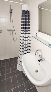 a white bathroom with a sink and a shower at Tussen de Diepen in Blokzijl