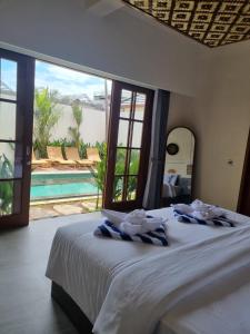 a bedroom with a bed with a view of a pool at Agusta Villas in Uluwatu