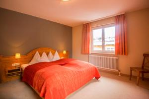 1 dormitorio con cama roja y ventana en Arcadia Appartments, en Bad Hofgastein