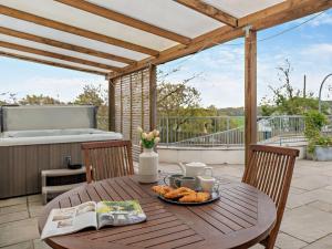 a wooden table with a plate of food on a patio at 1 Bed in High Bickington 55322 in High Bickington