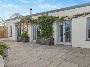 a white house with a patio with plants at 1 Bed in High Bickington 55322 in High Bickington