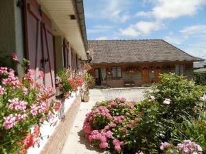 una casa con fiori sul lato di Chambres et Table d'Hôtes Les Trois Marquets a Bourthes