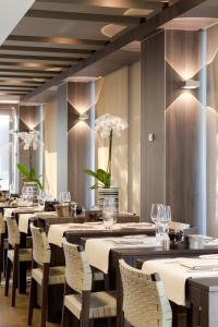 a dining room with tables and chairs and flowers at Holidaysuite Mathilda in Ostend