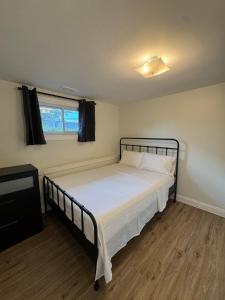 a bedroom with a bed with white sheets and a window at Comfort Stay by Stony Brook University & Hospital in Centereach