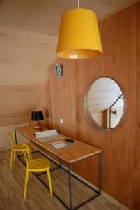 biurko z żółtym krzesłem i okrągłym lustrem w obiekcie Dom Pod Skałą w mieście Jeleniów