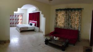 ein Wohnzimmer mit einem Bett und einem roten Sofa in der Unterkunft London lodges Guest House in Karatschi