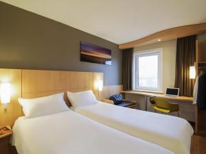a hotel room with a large bed and a window at ibis Rotterdam Vlaardingen in Vlaardingen