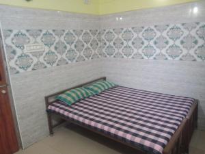 a bed in a room with a wall at Sri Kanna Lodge CMC Vellore in Vellore
