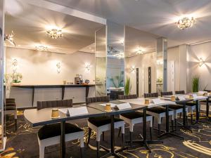 una sala de conferencias con mesas, sillas y espejos en Mercure Paris Place d'Italie, en París