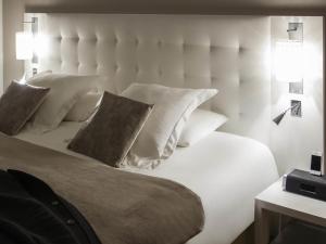 a bedroom with a white bed with pillows at Mercure Bourg En Bresse in Bourg-en-Bresse +81 photos