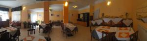 a restaurant with tables and chairs in a room at Hotel Villa Elle in Loano