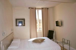 um quarto com uma cama branca e uma janela em Hotel Le St Jean em Beaumont-de-Lomagne