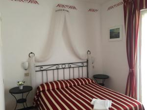 a bedroom with a bed with a red and white striped blanket at Hotel Villa Elle in Loano