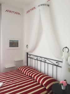 a bedroom with a bed with a red and white stripes at Hotel Villa Elle in Loano