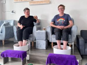 2 personnes assises sur des chaises dans une pièce dans l'établissement NET Spa & Massage Hoi An, à Thanh Ðông (1)