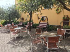 a row of tables and chairs in front of a building at Hotel Villa Elle in Loano