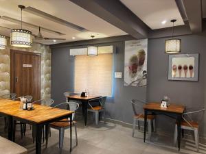 a dining room with tables and chairs in a restaurant at Air Avenue Hotel - Airport in Devanhalli