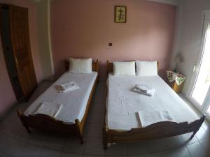 2 camas individuales en una habitación con ventana en Ioannis Avrades Apartments, en AgiaKampos