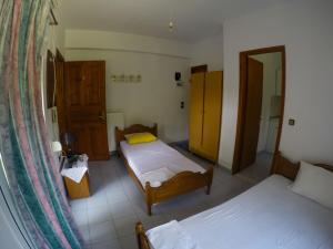 een kleine kamer met 2 bedden en een spiegel bij Ioannis Avrades Apartments in AgiaKampos