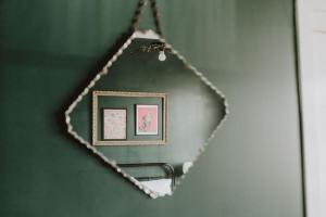 a mirror hanging on a green wall with a picture at The Kentish Tasmania in Oatlands
