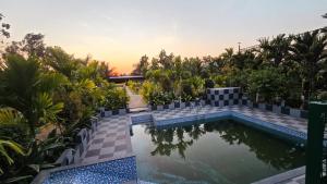 a swimming pool in the middle of a resort at Nature's Spark Resort in Sivasamudram