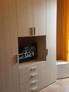 a living room with a tv in a cabinet at Perla Nera Guesthouse in Imperia