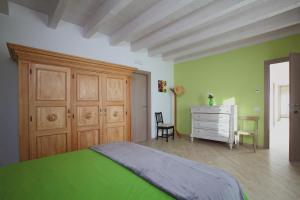 1 dormitorio verde con 1 cama y vestidor en Cascinetta32, en Invorio Inferiore