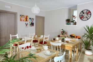 a dining room with wooden tables and white chairs at Cascinetta32 in Invorio Inferiore