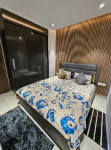 - une chambre avec un grand lit orné de fleurs bleues dans l'établissement The vantage sky, à Goa