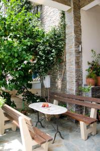 a patio with two benches and a table and a table and chairs at Ioannis Avrades Apartments in Agiokampos