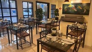 a dining room with tables and chairs and a couch at Casa Caonabo 35 en Santo Domingo 8 in Santo Domingo