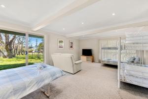 a bedroom with a bed and a bunk bed at Ocean Echoes - Pet Friendly with Ocean Glimpses in Culburra Beach