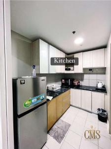 Il comprend une cuisine équipée d'un réfrigérateur en acier inoxydable. dans l'établissement Monarch Parksuites 2BR Deluxe 4 Family beds, à Sampong 20 autres photos