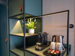 a shelf with a coffee maker on a table at Novotel Angers Lac de Maine in Angers