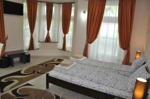 1 dormitorio con cama y alfombra en Guest House Best Food, en Subotica