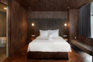 a bedroom with a large white bed and a couch at Bono Hotel by ARTOTEL - Pekanbaru in Pekanbaru +21 photos